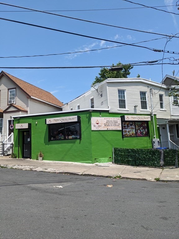 416 Crescent Avenue Chelsea, MA 02150 - Photo 2 of 21 a view of a big house with a small yard and garage