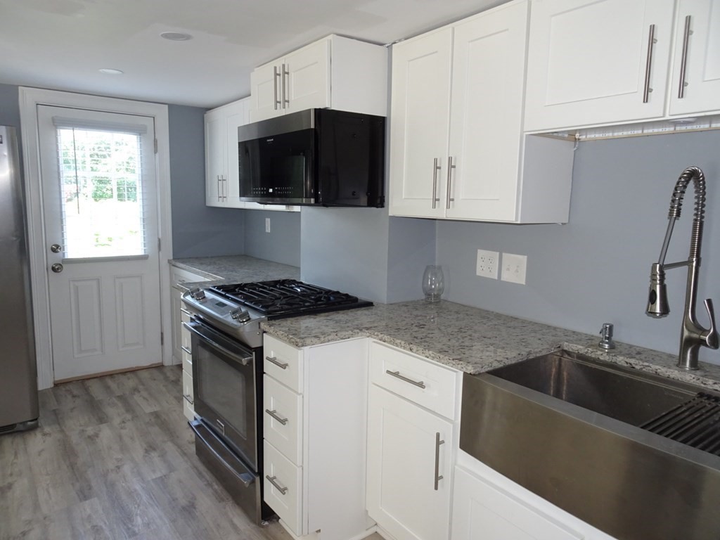 416 Crescent Avenue Chelsea, MA 02150 - Photo 6 of 21 a kitchen with granite countertop a sink and a stove top oven