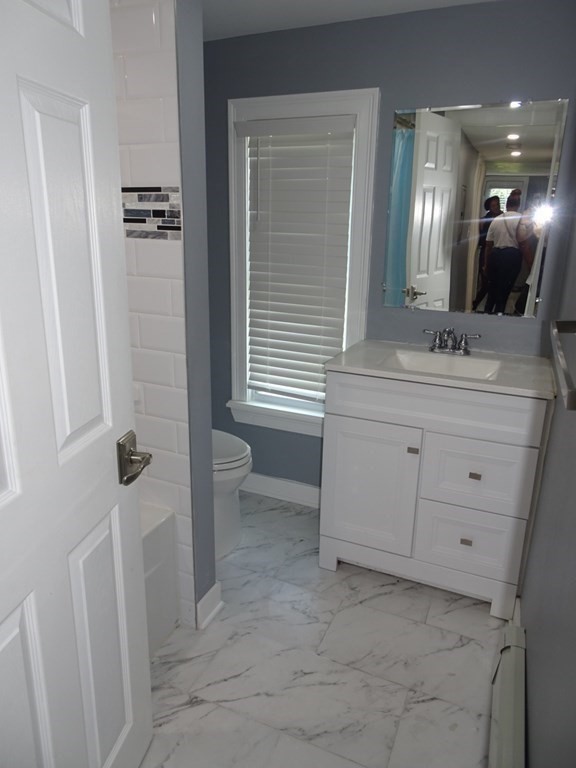 416 Crescent Avenue Chelsea, MA 02150 - Photo 9 of 21 a bathroom with a double vanity sink a toilet a and a mirror