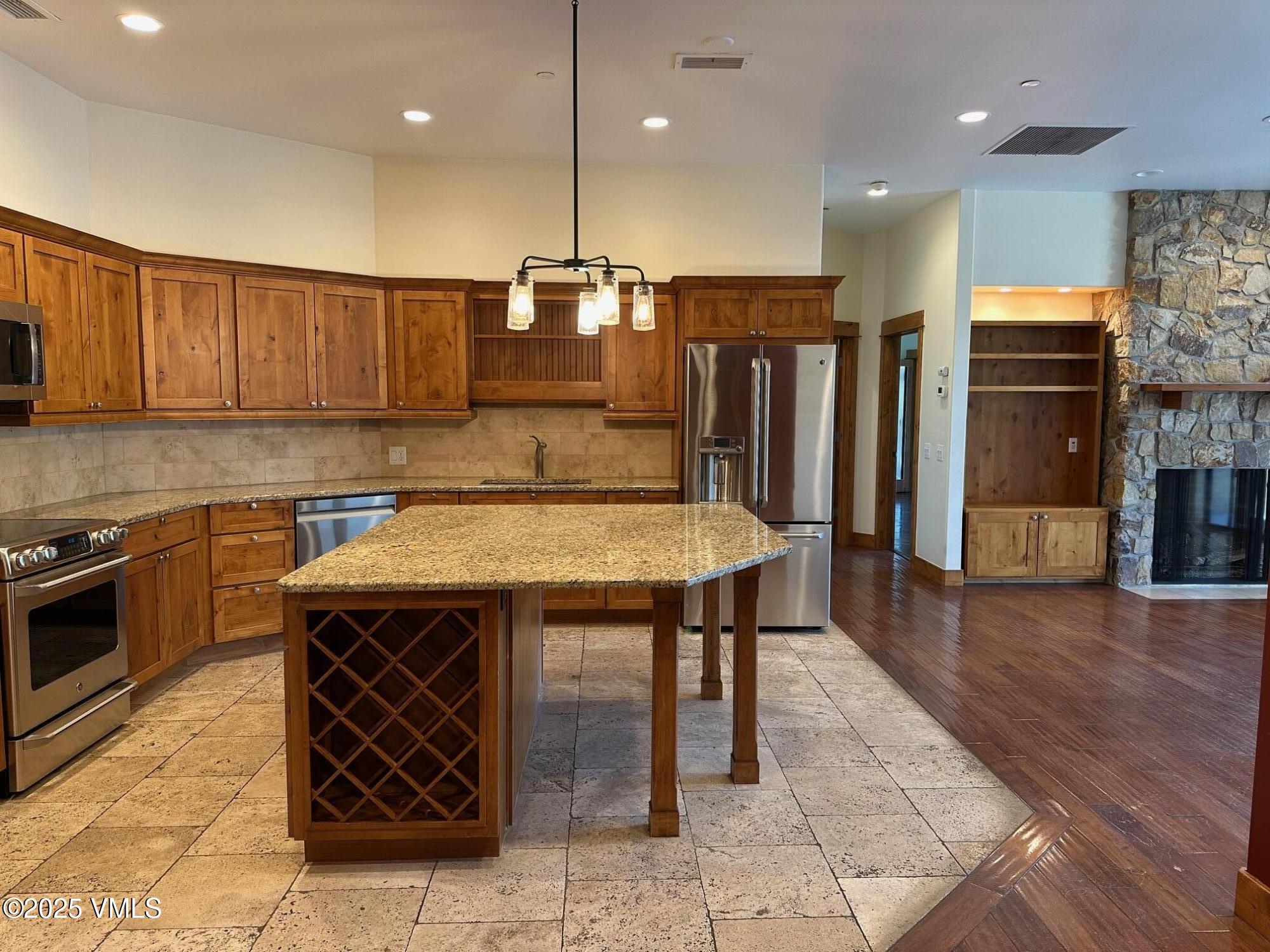 295 Main Street, Unit R204 Edwards, CO 81632 - Photo 2 of 9 a kitchen with stainless steel appliances granite countertop a table chairs sink and stove top oven