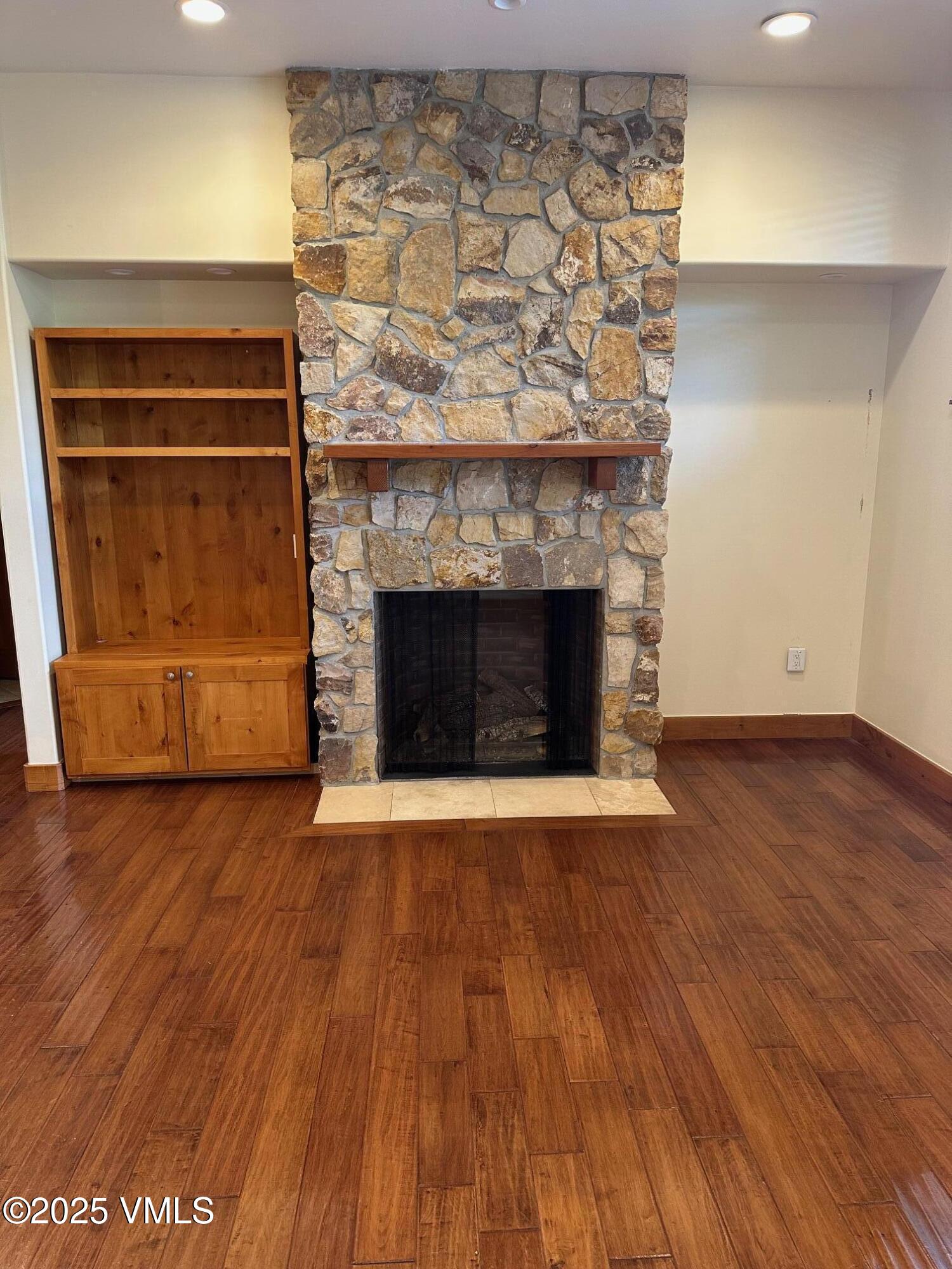 295 Main Street, Unit R204 Edwards, CO 81632 - Photo 4 of 9 an empty room with wooden floor and a fireplace