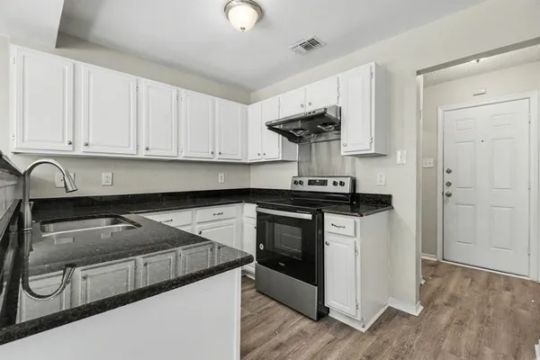 a kitchen with appliances a sink and cabinets