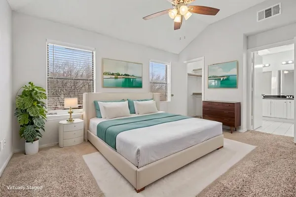 a bedroom with a large bed and a chandelier