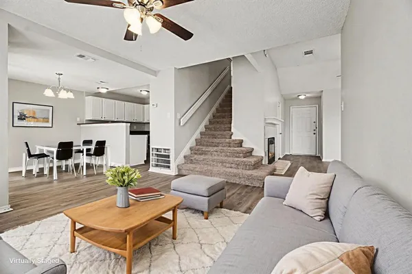 a living room with furniture kitchen view and a chandelier