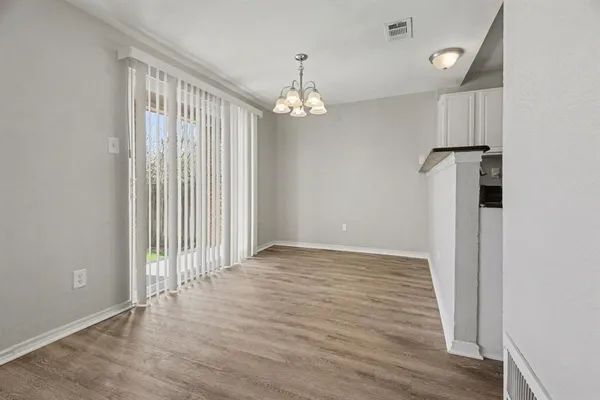 an empty room with wooden floor staircase and a ceiling fan