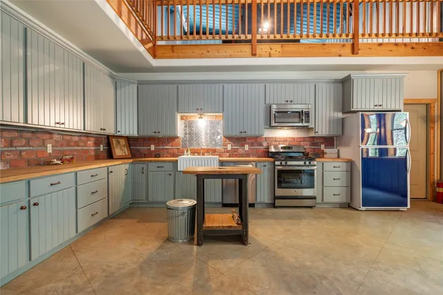 a kitchen with granite countertop a stove a sink and a refrigerator