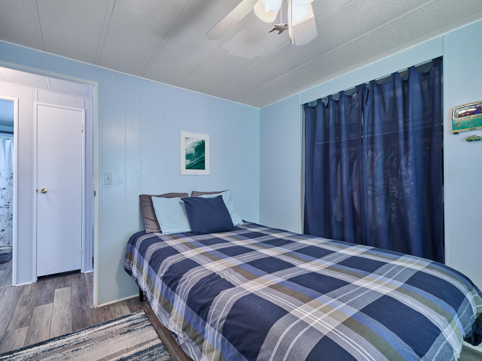 6977 Southeast Delegate Street Hobe Sound, FL 33455 - Photo 36 of 60 a bedroom with a large bed and a chandelier
