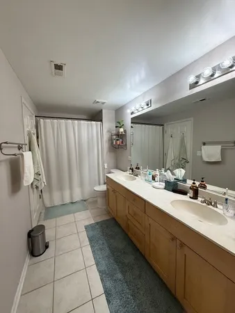 a large bathroom with a double vanity sink a mirror and a bathtub