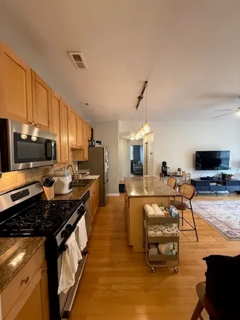 a kitchen with stainless steel appliances granite countertop a stove and a refrigerator