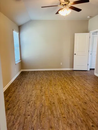 an empty room with a fireplace and chandelier