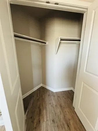 a view of walk in closet with empty racks