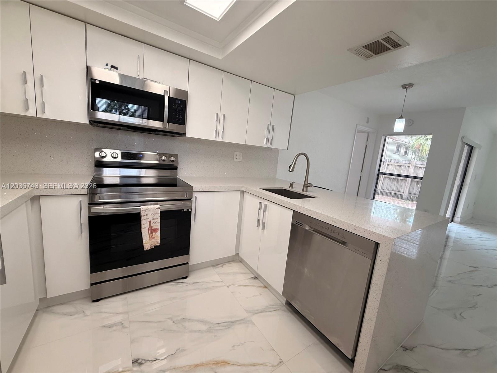 10875 Northwest 7th Street, Unit 1136 Miami, FL 33172 - Photo 11 of 25 a kitchen with granite countertop a stove top oven microwave and sink
