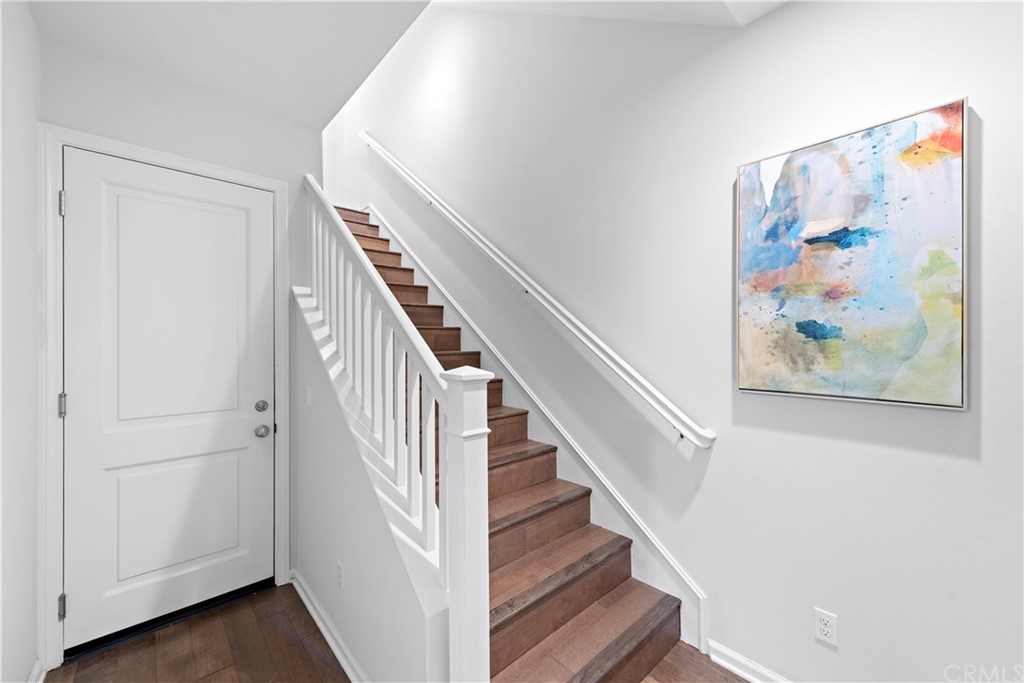 113 Painted Trellis Irvine, CA 92620 - Photo 4 of 26 a view of staircase with wooden floor and white walls
