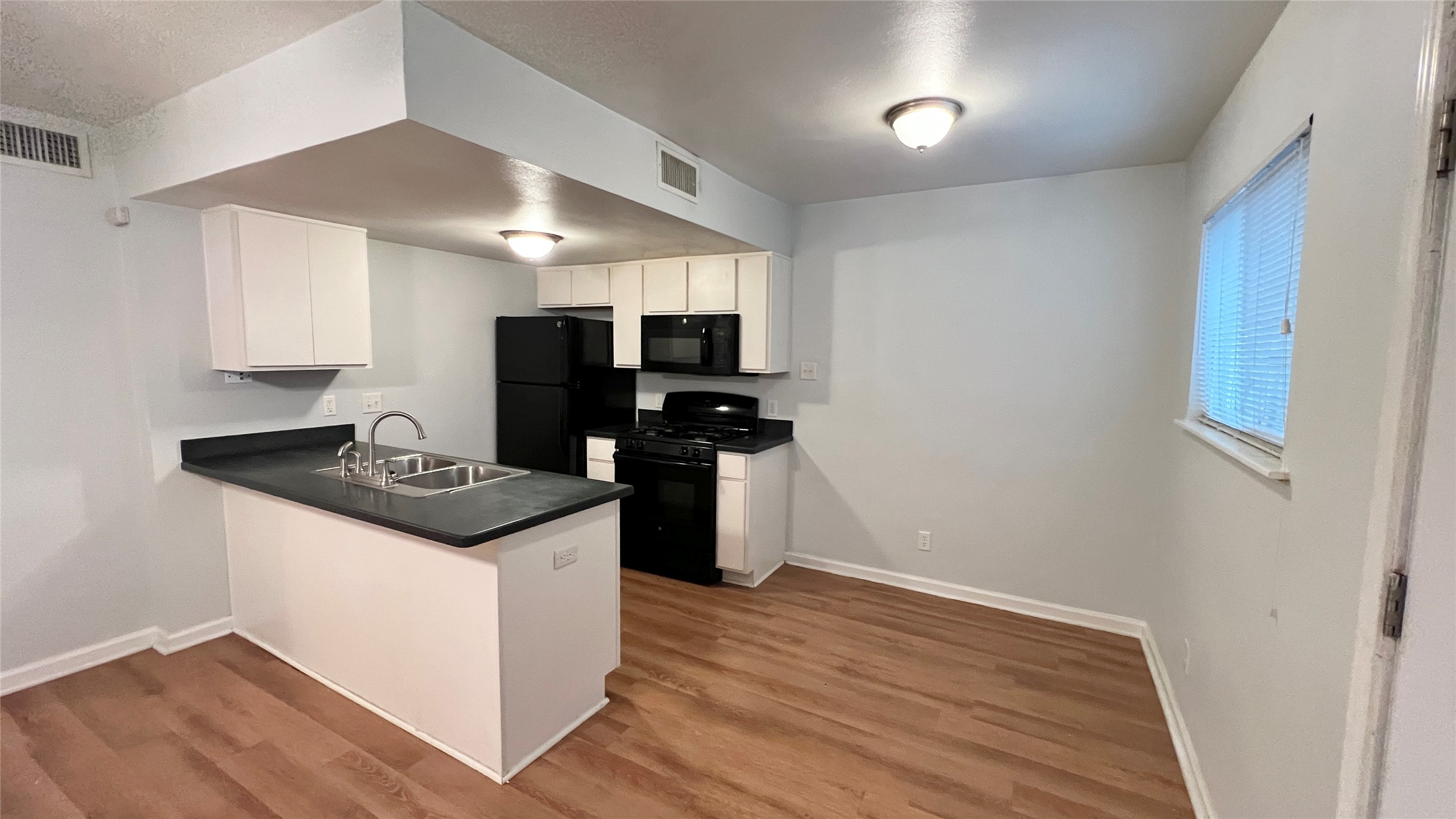 2301 Ohlen Road, Unit 104 Austin, TX 78757 - Photo 4 of 9 a kitchen with granite countertop a stove and a sink