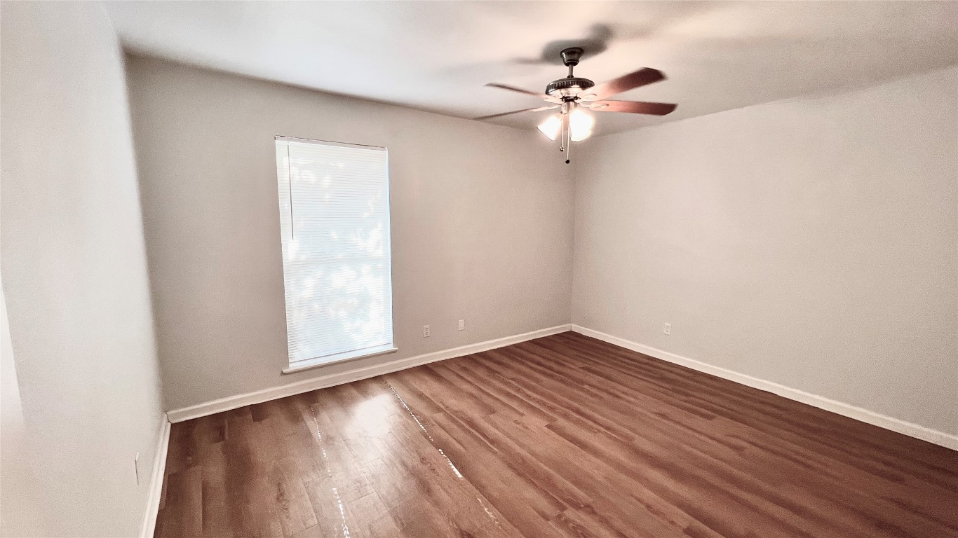 2301 Ohlen Road, Unit 107 Austin, TX 78757 - Photo 7 of 9 an empty room with wooden floor fan and windows