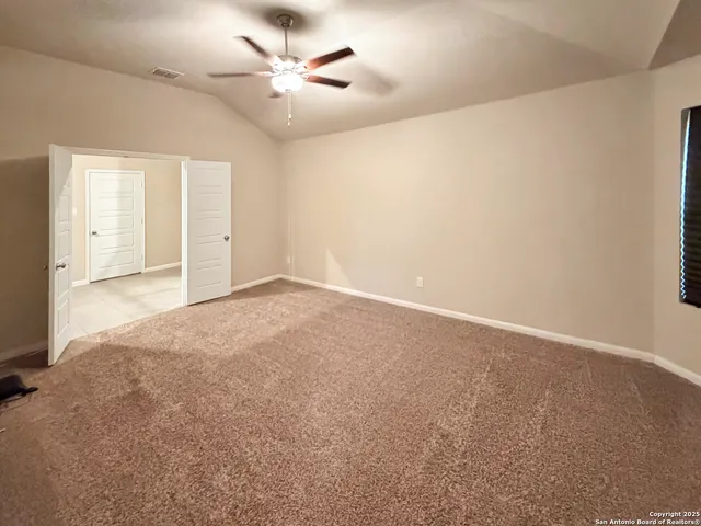 en empty room with windows and ceiling fan