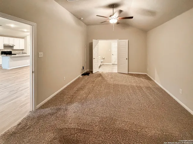 an empty room with fan and entrance