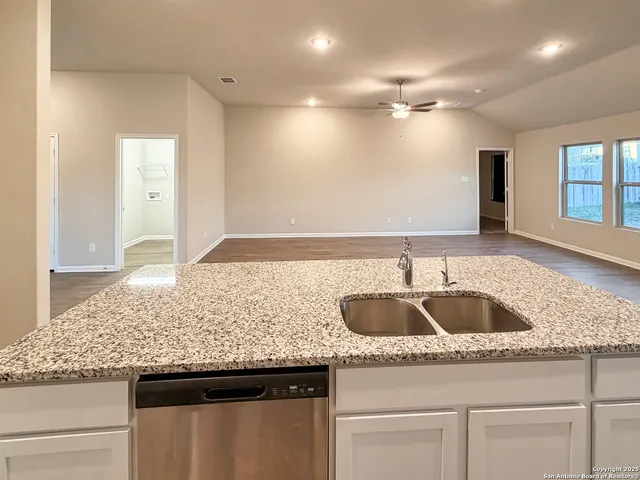 a kitchen with a sink and a wooden floor