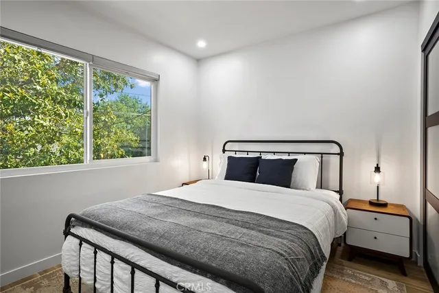 a bedroom with a bed and a large window