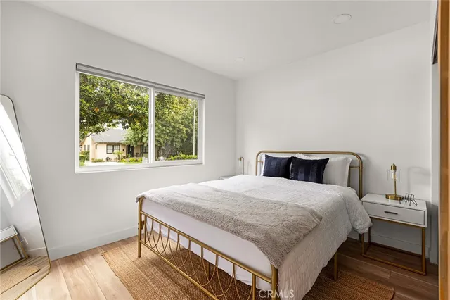 a view of a bedroom with wooden floor and bathroom
