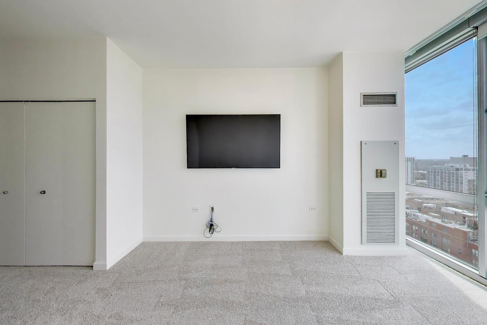 1629 South Prairie Avenue, Unit 1806 Chicago, IL 60616 - Photo 9 of 27 a view of an empty room with a cabinet and a flat screen tv