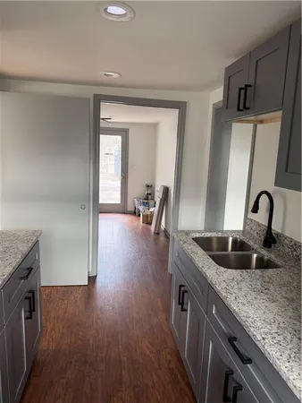 a kitchen with granite countertop a sink and wooden floor