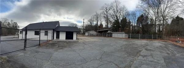 a view of house with yard and sitting area