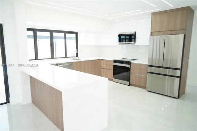 a kitchen with stainless steel appliances granite countertop a refrigerator and a stove