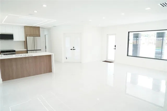 a large white kitchen with cabinets