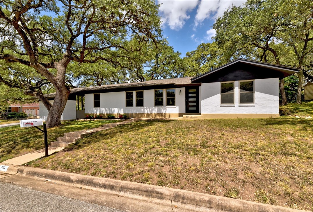 4402 Dudley Drive Austin, TX 78735 - Photo 1 of 1 a front view of a house with a yard tree and wooden fence