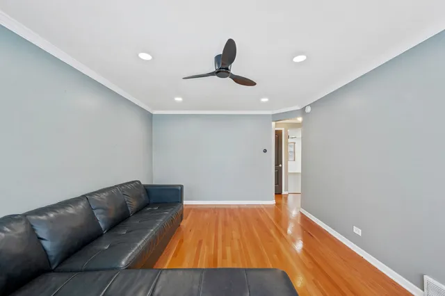 a living room with hard wood floors and a ceiling fan