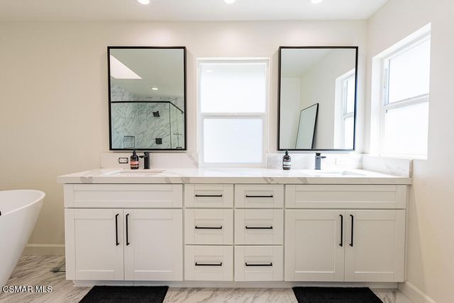 a bathroom with double vanity sink a mirror and a toilet