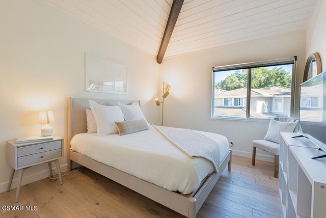 a bedroom with a bed and a large window