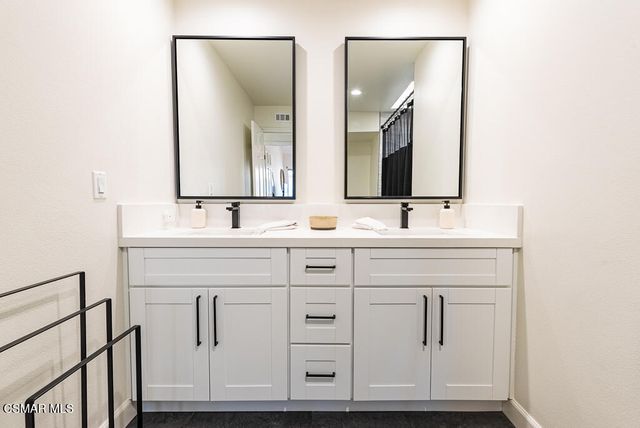 a bathroom with double sink and a mirror
