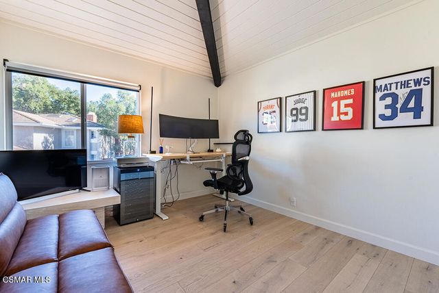 a view of a workspace with furniture and a window