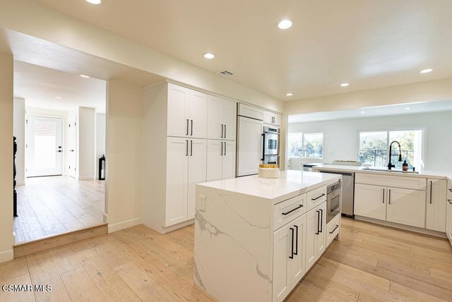 a kitchen with white cabinets and white appliances