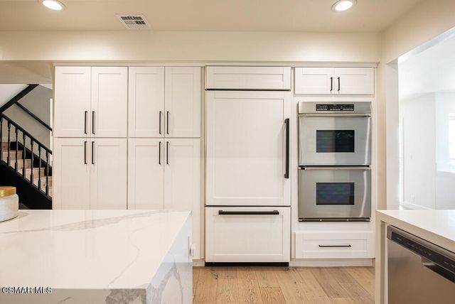 a kitchen with stainless steel appliances a refrigerator and a stove top oven