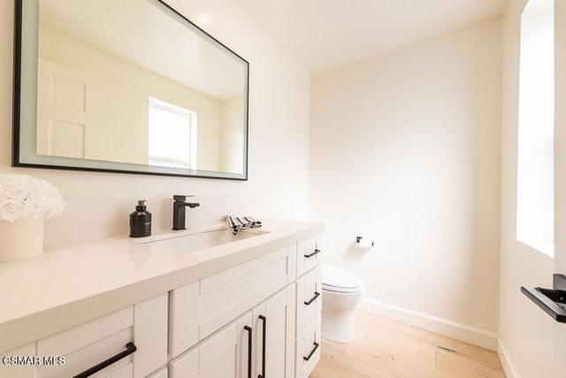 a bathroom with a toilet a sink a vanity and mirror