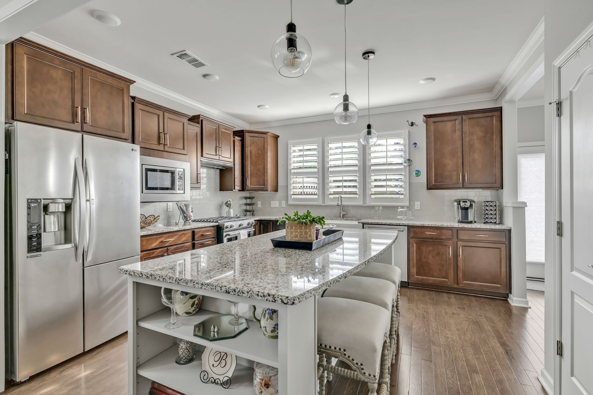 843 Clay Place Spring Hill, TN 37174 - Photo 9 of 56 a kitchen with stainless steel appliances granite countertop a refrigerator a sink dishwasher a stove and a dining table with wooden floor