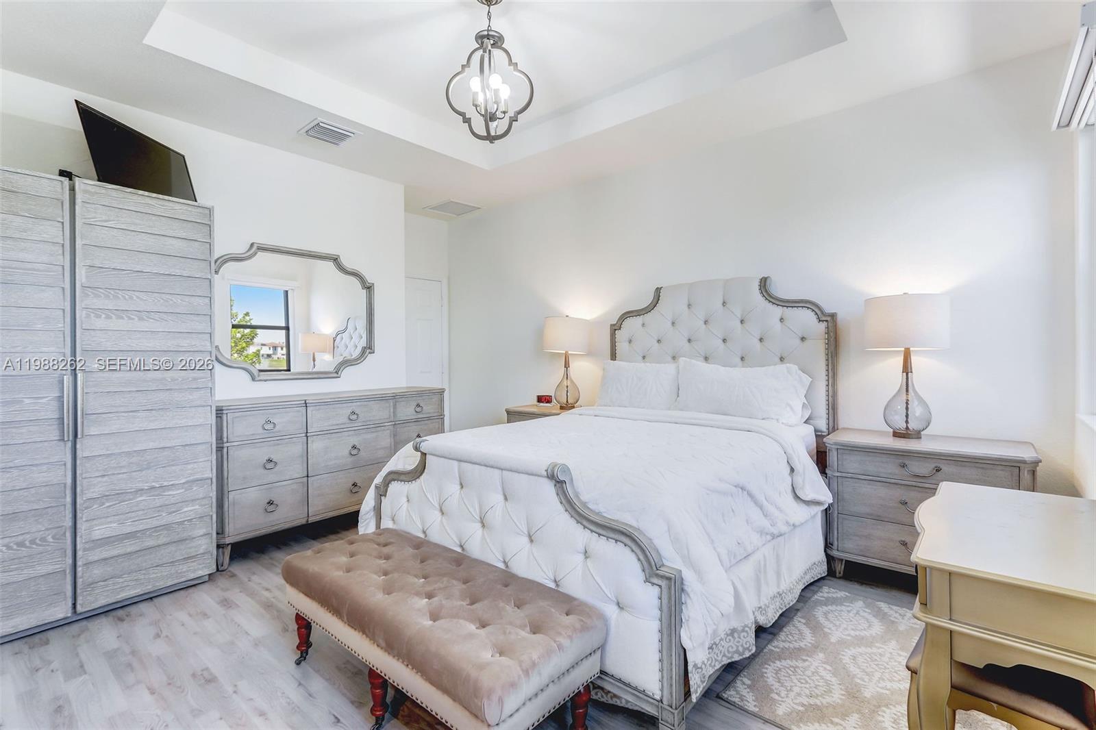 3375 West 100th Terrace Hialeah, FL 33018 - Photo 12 of 27 a bedroom with a bed and a chandelier