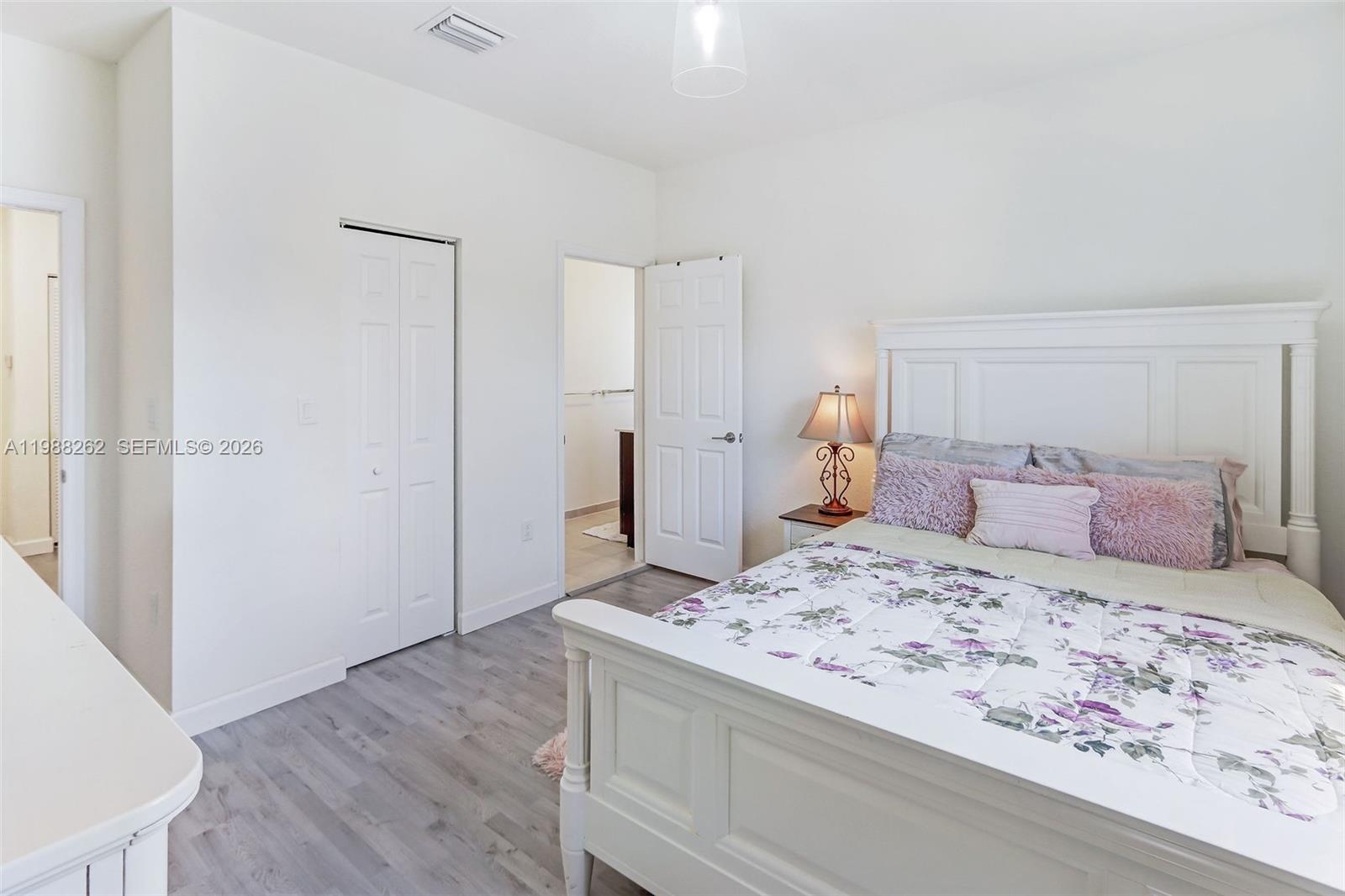 3375 West 100th Terrace Hialeah, FL 33018 - Photo 16 of 27 a bedroom with a bed and wooden floor