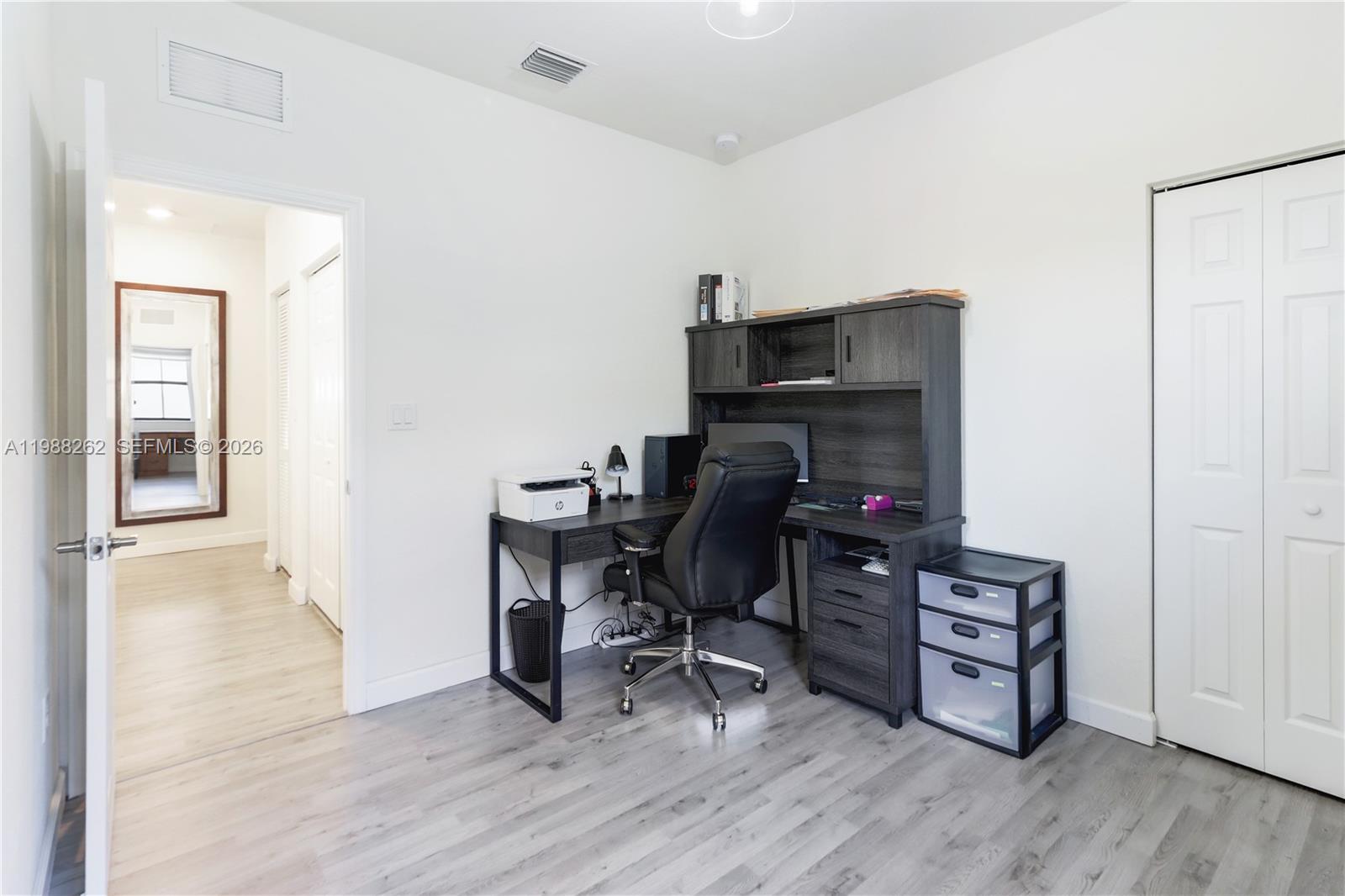 3375 West 100th Terrace Hialeah, FL 33018 - Photo 17 of 27 a view of a workspace with furniture and wooden floor