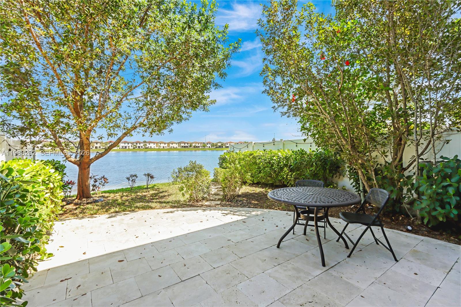 3375 West 100th Terrace Hialeah, FL 33018 - Photo 6 of 27 a view of a backyard with table and chairs under an umbrella