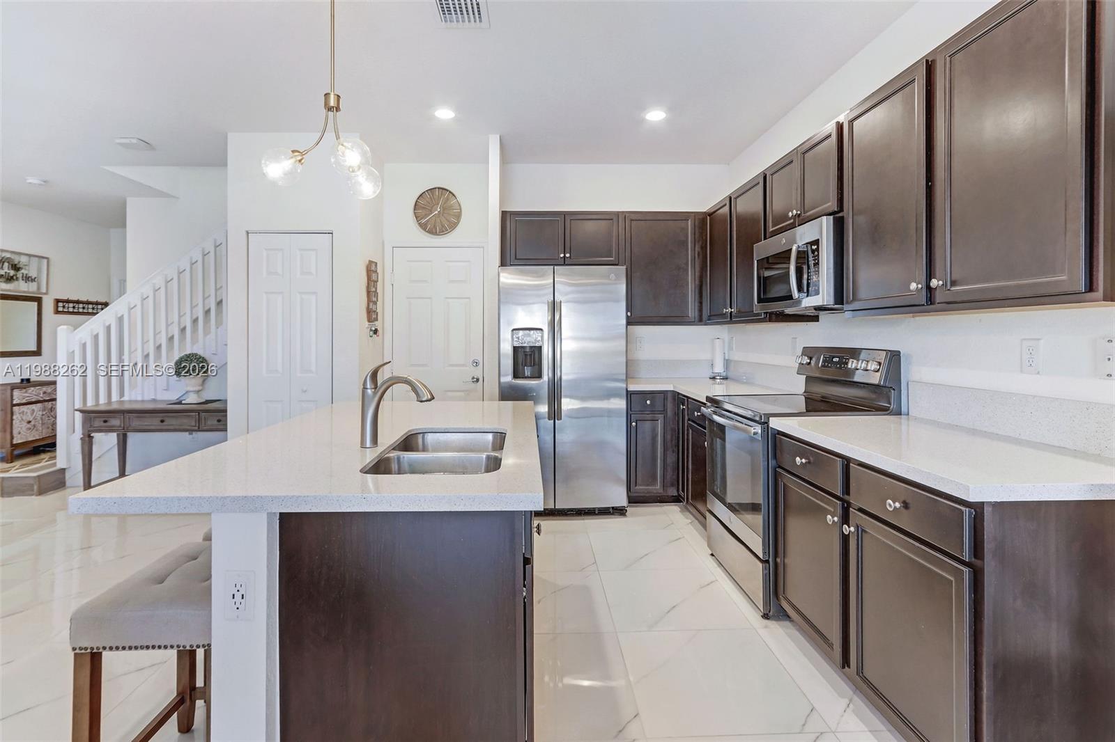 3375 West 100th Terrace Hialeah, FL 33018 - Photo 8 of 27 a kitchen with stainless steel appliances granite countertop a sink a stove and a refrigerator