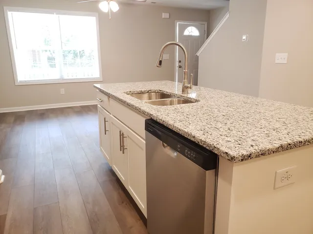 a kitchen with a sink and wooden floor