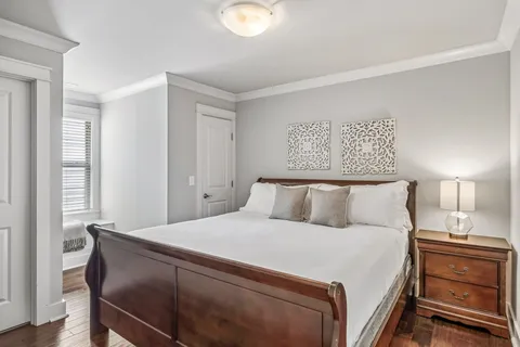 a bedroom with a bed and a lamp on dresser