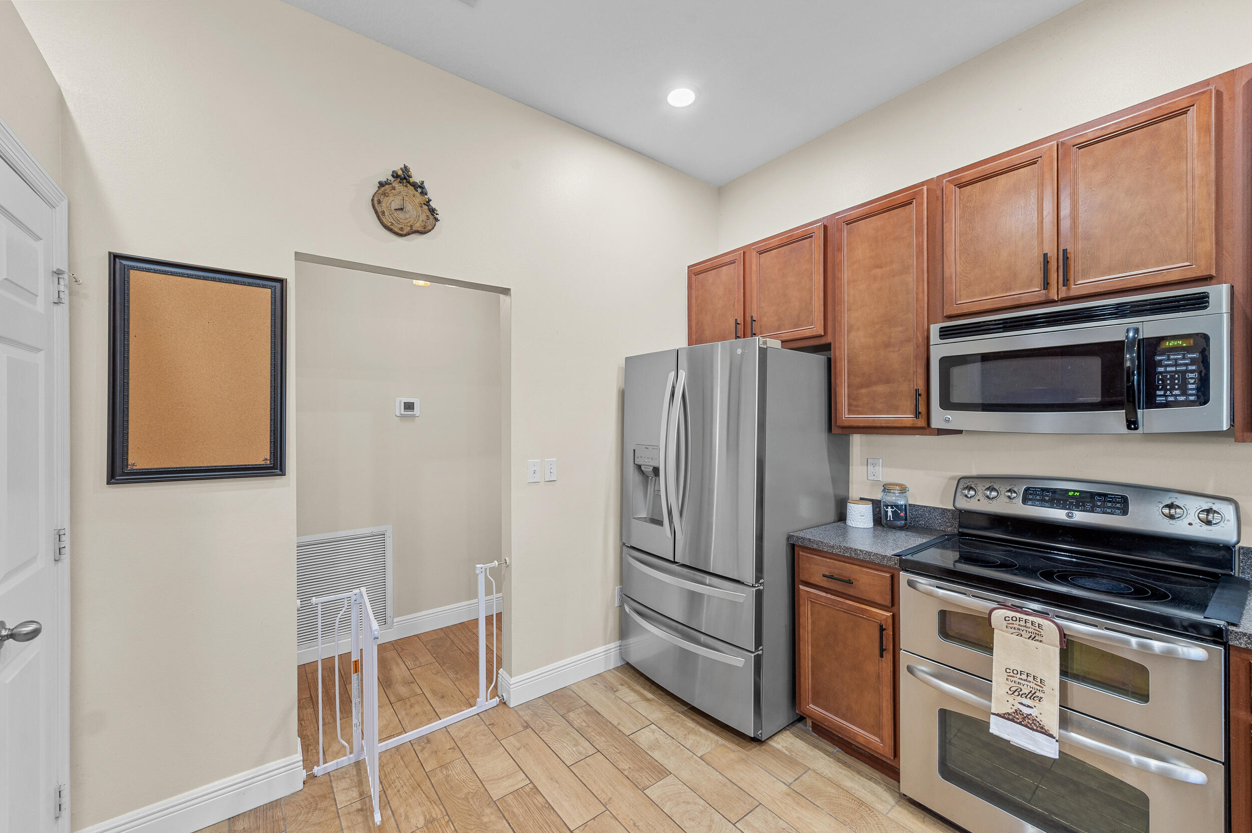 4164 Southwest Spickler Street Port St. Lucie, FL 34953 - Photo 12 of 35 a kitchen with stainless steel appliances a refrigerator a stove top oven and cabinets