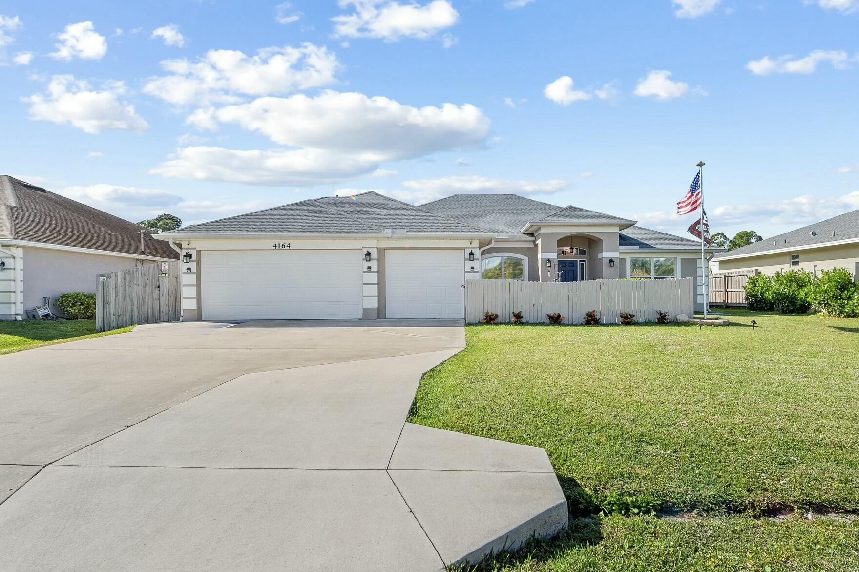 4164 Southwest Spickler Street Port St. Lucie, FL 34953 - Photo 2 of 35 a front view of a house with a garden and yard