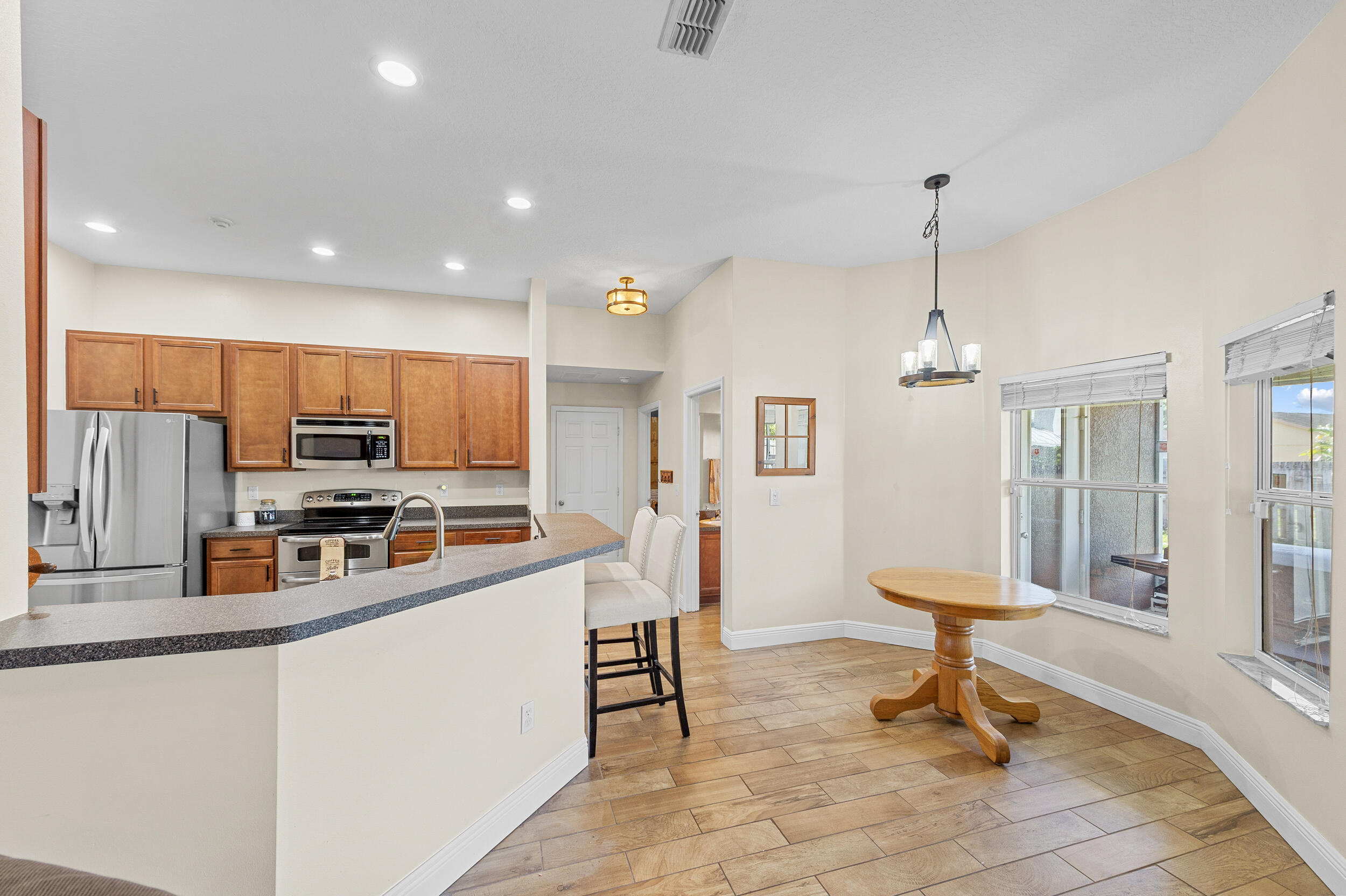 4164 Southwest Spickler Street Port St. Lucie, FL 34953 - Photo 10 of 35 a living room with stainless steel appliances kitchen island furniture and a view of kitchen