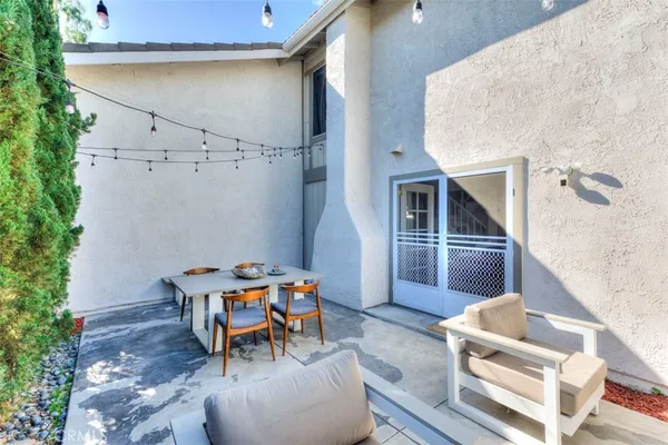 a backyard of a house with barbeque oven table and chairs